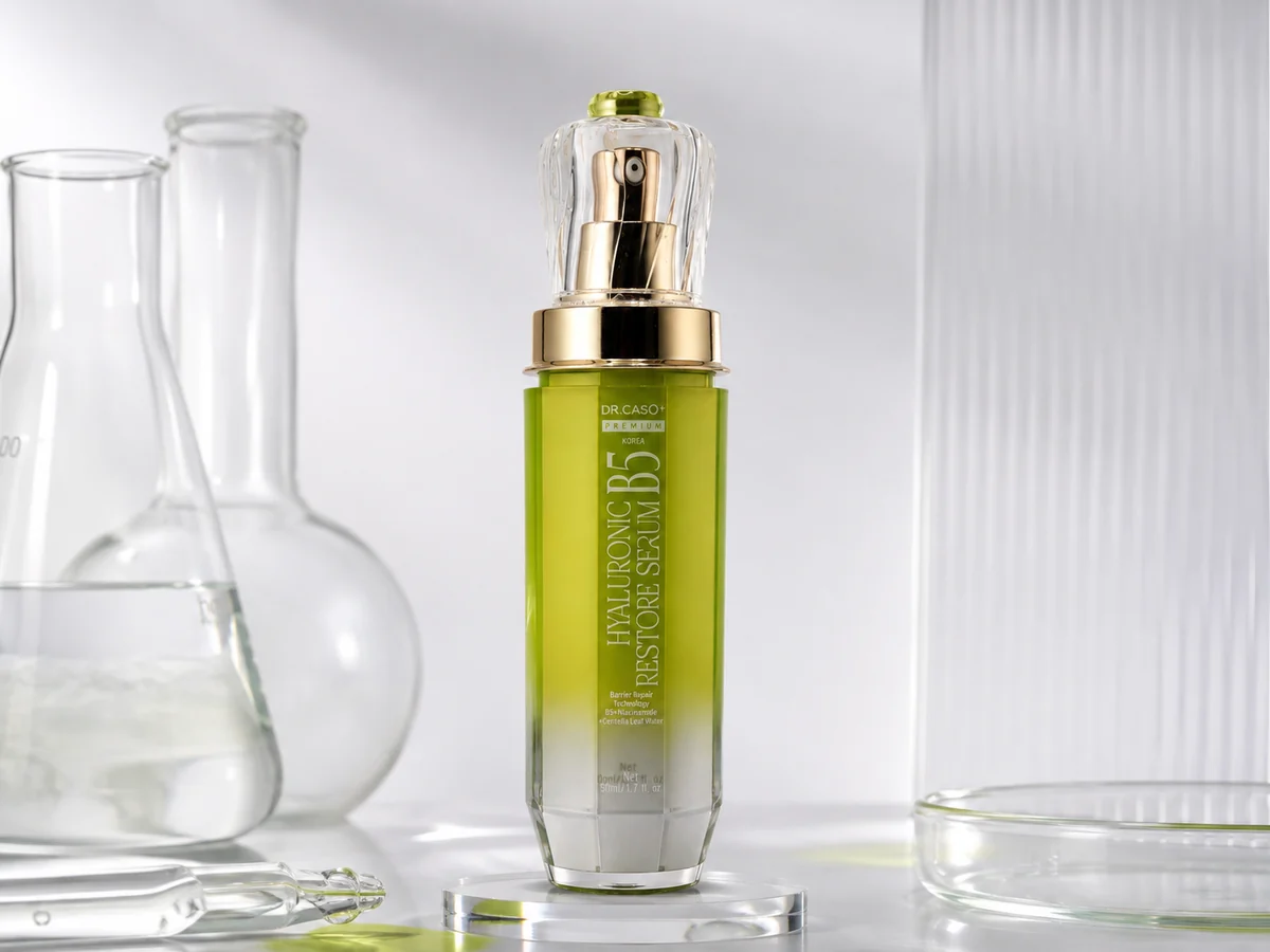 Chai Hyaluronic B5 Restore Serum đặt trên bệ trong suốt, bên bình thủy tinh.