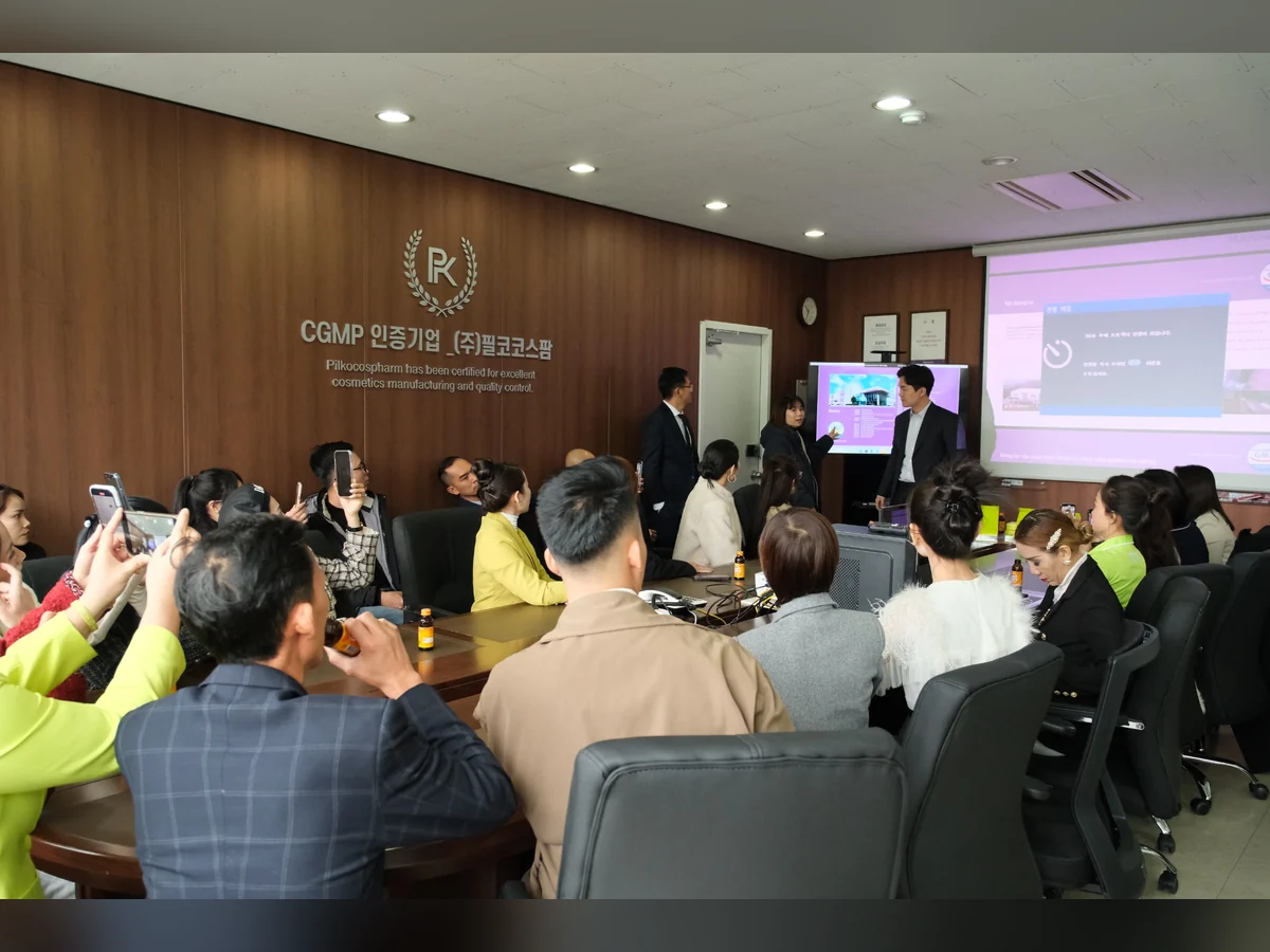 Buổi thuyết trình trong phòng đào tạo có màn chiếu và học viên ngồi quanh bàn.