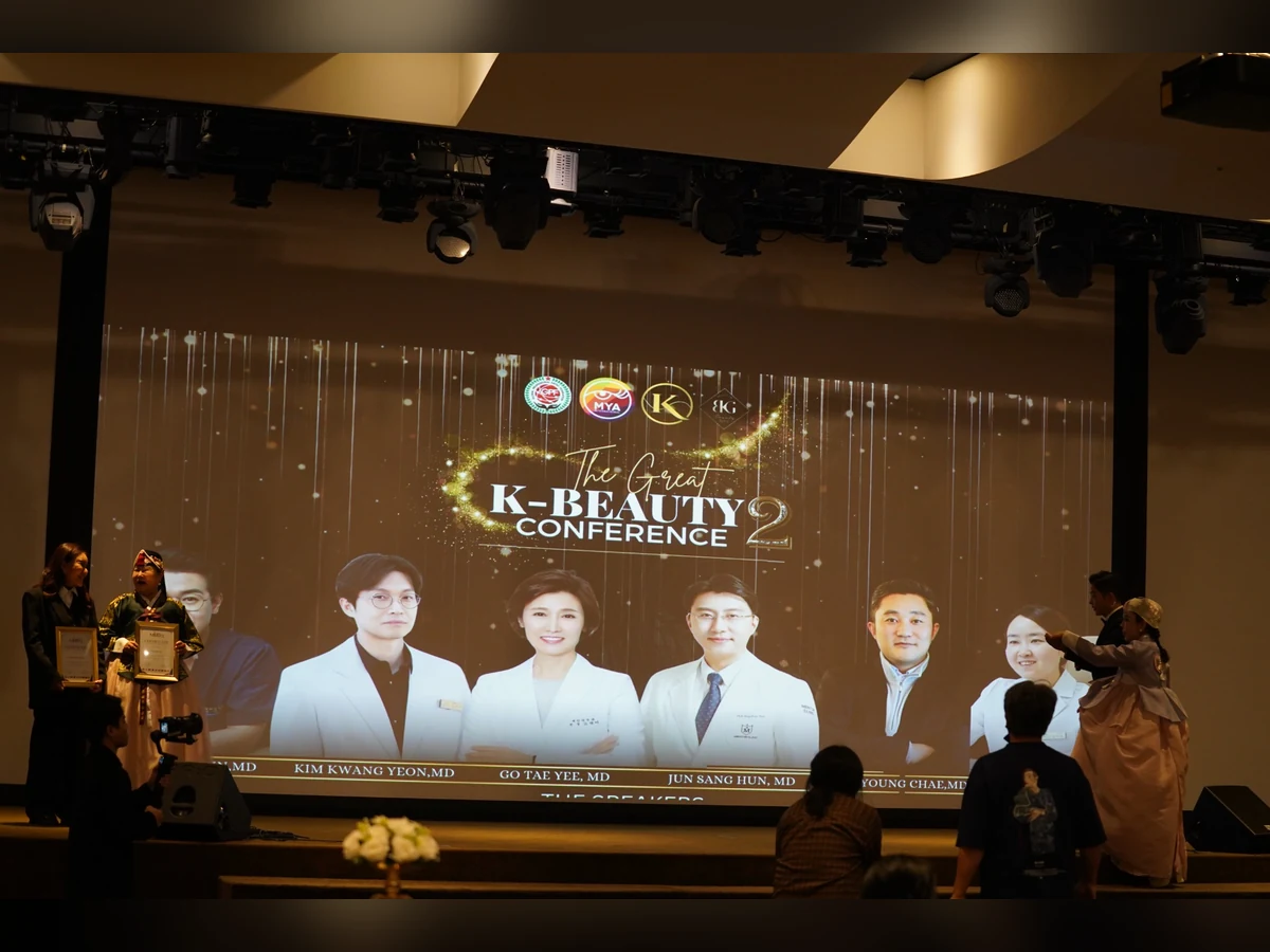 Sân khấu K-Beauty Conference nhìn từ khán phòng, có màn hình giới thiệu diễn giả.