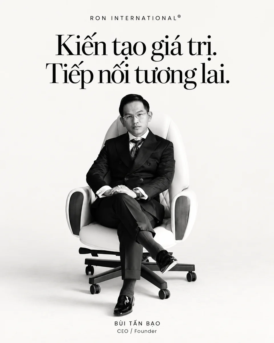 Bùi Tấn Bạo ngồi ghế trong bộ vest, cùng thông điệp Kiến tạo giá trị. Tiếp nối tương lai.